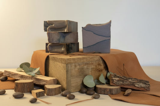 Three bars of soap on a wooden block with a neutral background
