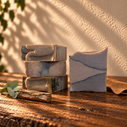 Hickory & Suede Handcrafted Soap on a dark rustic wooden table with scent accents in warm natural light.