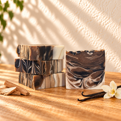 Sandalwood Vanilla Handcrafted Soap showing the handcrafted bar design on sunlit wood with simple scent accents against an ivory wall.